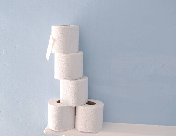 Toilet paper rolls on light blue background. - Φωτογραφία, εικόνα