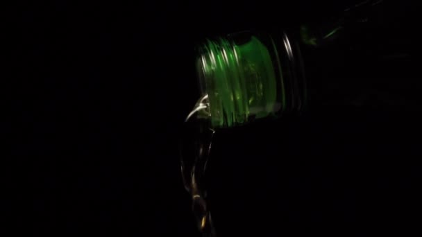 Viskivirta valuu vihreästä pullosta alkoholin alta mustan taustan lähikuvaan. Hidasta vauhtia. Makroruiske. Alkoholin käsite
 - Materiaali, video