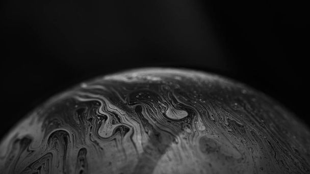 Soap bubble on dark background. Lots of colors and magical texture was created thanks to strong lighting. - Photo, Image