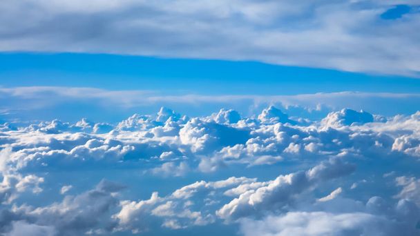 青い空と飛行機の窓からの雲の上の空の景色の素晴らしい映像. - 写真・画像
