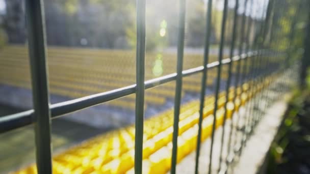 The stadium is fenced with an iron fence. Empty seats in the stadium without spectators and fans. Cancellation of matches due to the coronavirus pandemic, quarantine. Access is closed. - Footage, Video