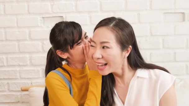 Aziatisch familie mam en tiener dochter vertellen roddel en delen in een kamer met de natuur zonlicht thuis. - Video