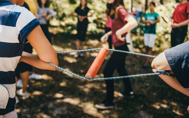 Young people pulled the ropes between each other. Team building exercise, team spirit. Strengthening team relationships. Unity among people teams - Valokuva, kuva