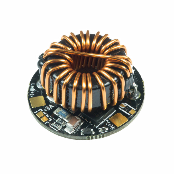 Tablero de PCB de controlador led redondo negro con bobina de inductancia y componentes de montaje en superficie en una vista de primer plano
 - Foto, Imagen