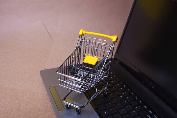 End of online sales. Online shopping, shopping cart on laptop keyboard. - Photo, Image