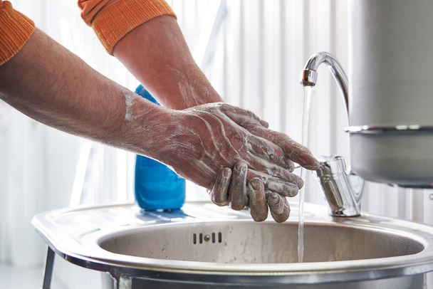 Механічне миття брудних рук з милом після роботи
 - Фото, зображення