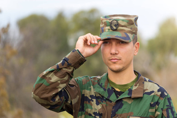 Soldado saluda y sostiene a la gente gorra joven
 - Foto, imagen