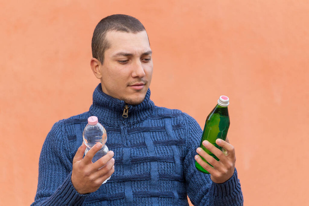 笑顔の男は手にガラス瓶を見ている。非プラスチックの概念 - 写真・画像
