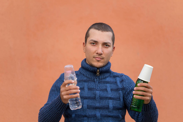 男はコップで覆われた水のボトルを手に持っている。一方、プラスチック包装、一方で紙コップ付きのガラス - 写真・画像