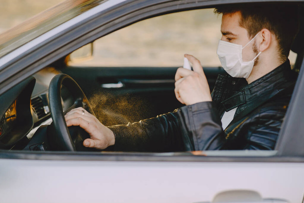 Man in a mask disinfect the car - Foto, Bild