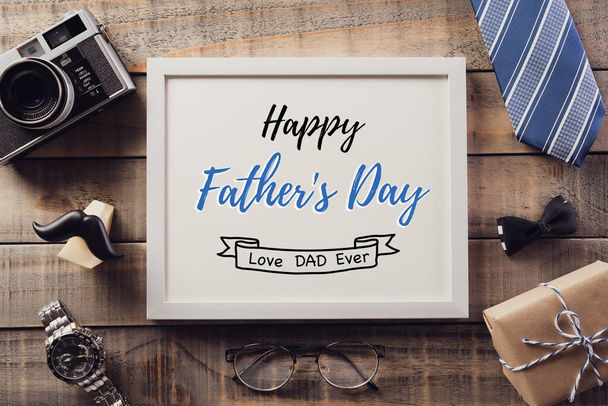 Happy Fathers Day achtergrond concept met koffiebeker, versierde strikje, stropdas, brillen, retro camera, geschenkdoos en snor op oude houten ondergrond. Vintage stijl. - Foto, afbeelding