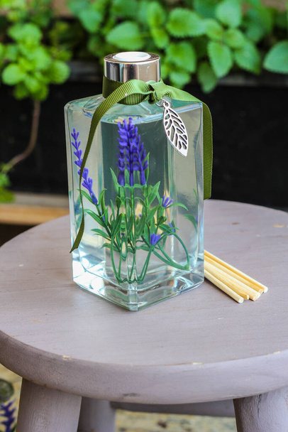 Aromatischer Lufterfrischer in einer transparenten Glasflasche mit Lavanda im Inneren - Foto, Bild