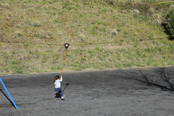 Ιαπωνικό κορίτσι (5 ετών) παίζει με ιπτάμενη αλεπού - Φωτογραφία, εικόνα