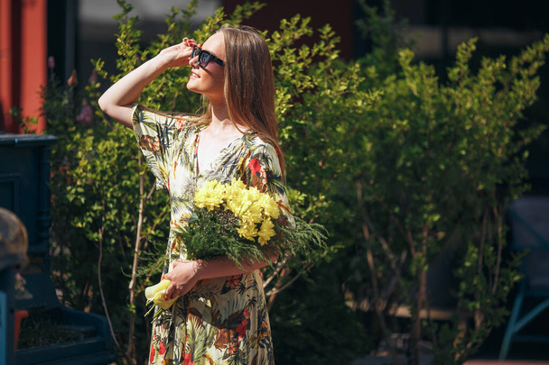 Ragazza elegante in posa in un vestito in un parco primaverile soleggiato
. - Foto, immagini