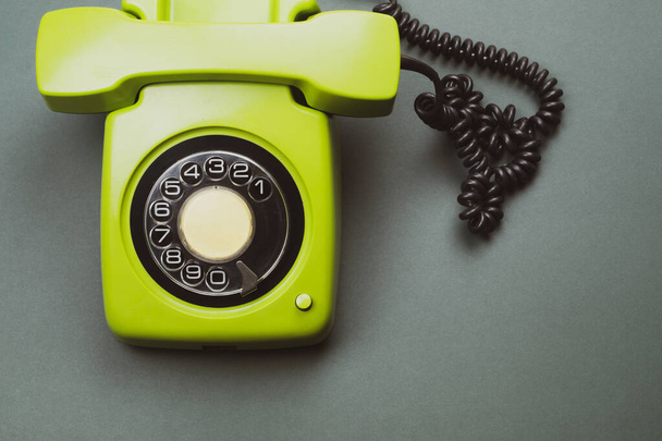 Classic phone with handset. vintage green telephone with phone receiver isolated on color background. old communication technology. copy space - Фото, изображение