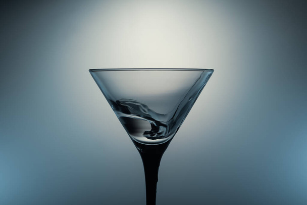 Martini glass with water splash on glowing background. transparent cocktail - Фото, изображение