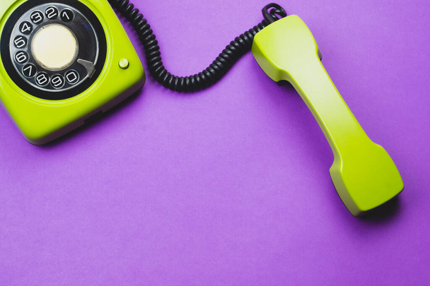 Classic phone with handset. vintage green telephone with phone receiver isolated on purple background. old communication technology. copy space - Photo, Image