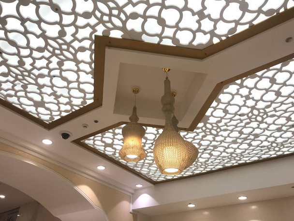 Projeto falso do teto do gesso suspenso com lustre bonito para uma decoração da área de entrada do hotel do banquete
 - Foto, Imagem