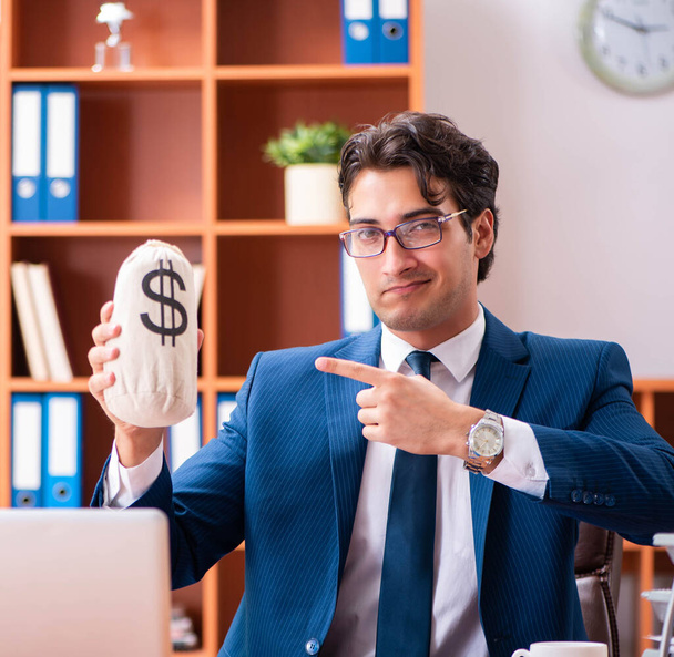 Молодой привлекательный бизнесмен работает в офисе - Фото, изображение