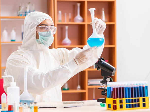 研究室で働いてる保護服を着た若い生化学者 - 写真・画像