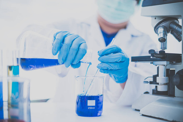  Equipamentos e experiências científicas cientista derramamento de óleo com tubo de ensaio azul fazendo pesquisa em laboratório
. - Foto, Imagem