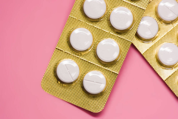 pacotes de pílula selada branca com fundo rosa macro vista superior
 - Foto, Imagem