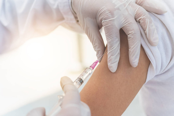 The doctor is currently treating patients by injecting arms. Vaccination or medication to prevent and treat viruses. - Photo, Image