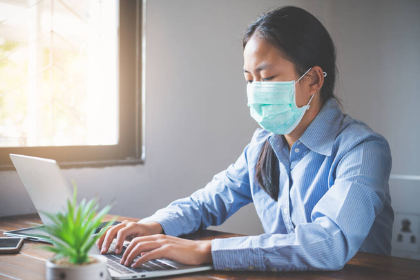 Женщина, работающая перед ноутбуком во время вспышек вирусковидных вирусов-19 по всему миру, должна быть задержана и работать дома в одиночку, чтобы предотвратить вирус
. - Фото, изображение