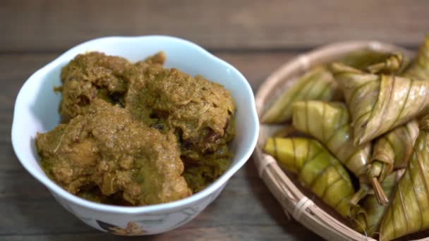 Cinematische shot van ketupat palas en kip rendang, traditionele malay cuisines meestal geserveerd tijdens eid - Video