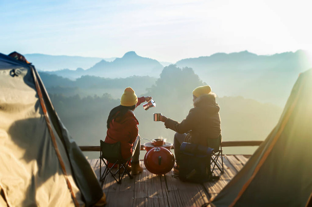 Two women camping in the mountains and drinking coffee. - Photo, Image