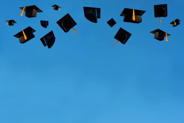 Οι μαθητές που κρατούν ένα πλάνο του καπέλου αποφοίτησης από το χέρι τους σε ένα φωτεινό ουρανό κατά τη διάρκεια της τελετής επιτυχία αποφοίτων στο Πανεπιστήμιο, Concept of Successful Education in Hight School, Συγχαρητήρια Βαθμός  - Φωτογραφία, εικόνα