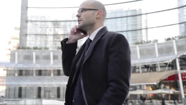 elegantní pohledný podnikatel na telefonu v obchodní čtvrti - Záběry, video