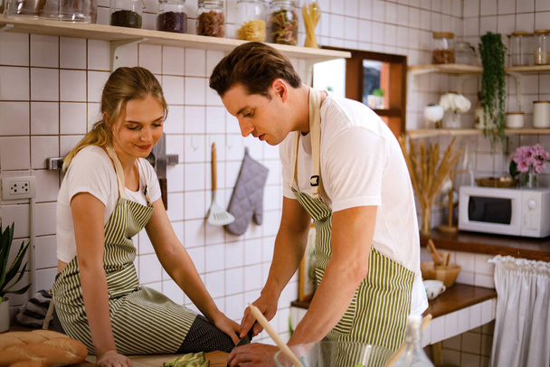 Young couples are enjoying cooking at the kitchen in working from home, COVID-19. - Photo, Image