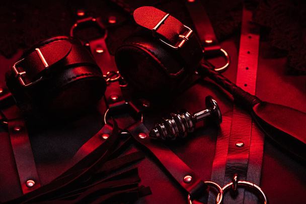 Set für BDSM Sex im Geschäft. Lederpeitsche und Handschellen mit Choker und Analplug - Foto, Bild
