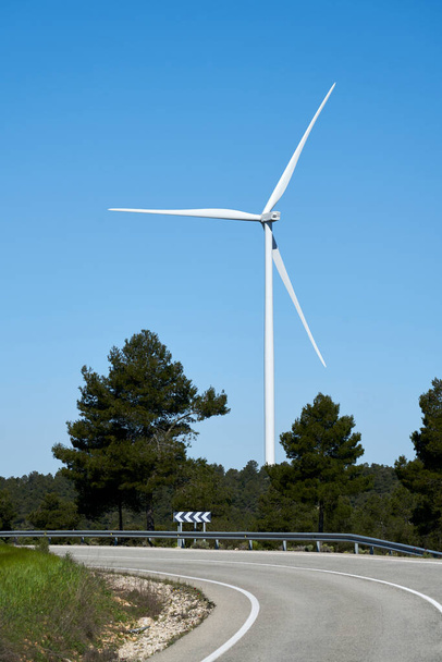 Tie lähellä ekologisia tuulimyllyjä sähkön tuottamiseksi luonnonympäristössä
 - Valokuva, kuva