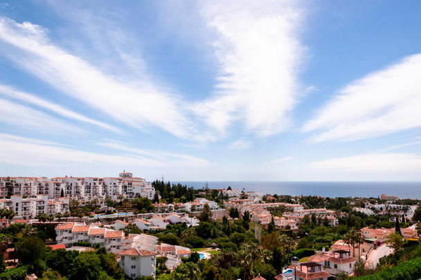 Panoramatický výhled na španělské pobřežní město, moře a lehká péřová mračna na obloze - Fotografie, Obrázek