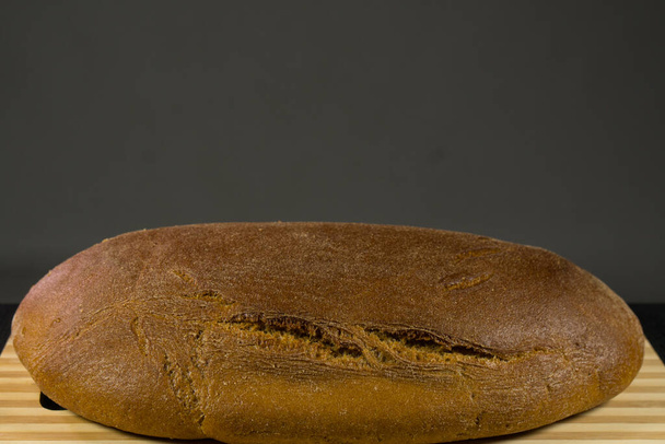 Черный хлеб с кунжутом. На деревянной доске
 - Фото, изображение