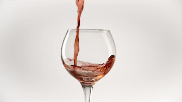 Lassú mozgás öntő vörösbor palackból serlegbe fehér alapon - Felvétel, videó