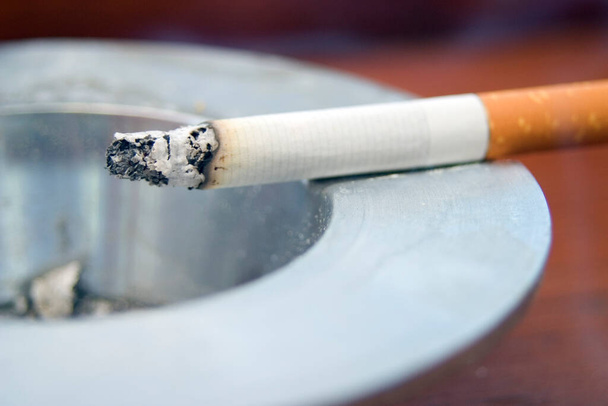 Queima de cigarro fumando em um cinzeiro
 - Foto, Imagem