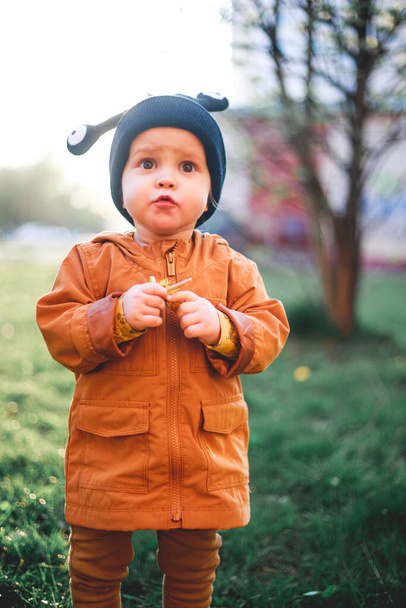portrait of a one year old boy with a snail wool cap on the background of nature - Foto, imagen