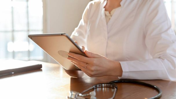 Жінка-лікар консультує клієнта онлайн на планшеті
 - Фото, зображення