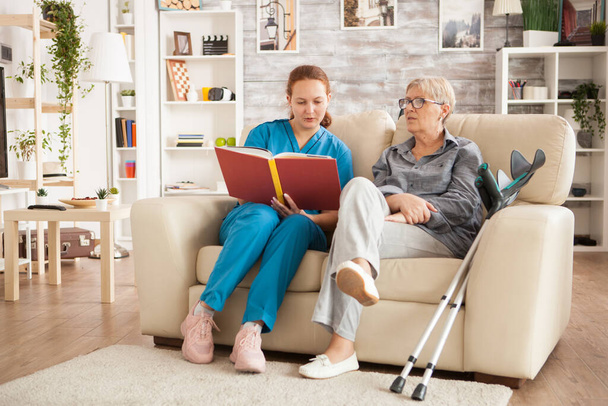 Enfermera leyendo un libro sobre el hogar de ancianos
 - Foto, imagen
