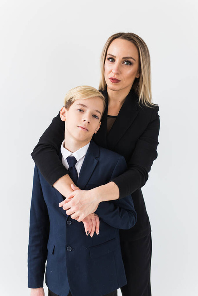 Teenager and single parent - Young mother and son standing together on white background. - Foto, Imagen