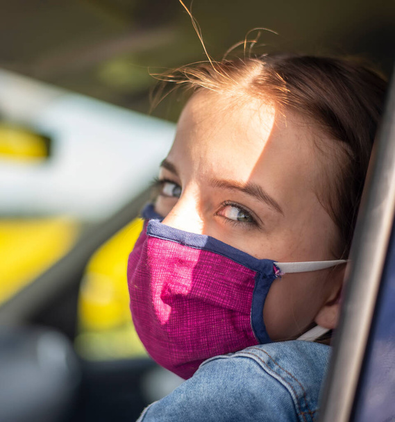 dívka s chráničem úst čeká v autě - Fotografie, Obrázek