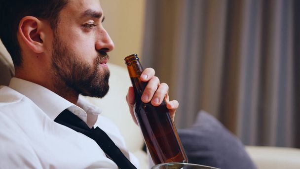 Side view of businessman drinking beer - Zdjęcie, obraz