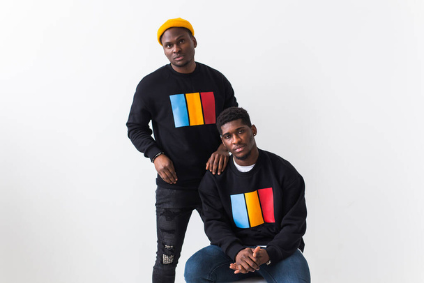 ストリートファッションと友情のコンセプト-黒のスタイリッシュなスウェットシャツを着た2人のアフリカ系アメリカ人の若者. - 写真・画像