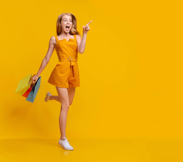 Nagy üzlet. Izgatott lány fut a bevásárló táskák és rámutatva a szabad hely - Fotó, kép
