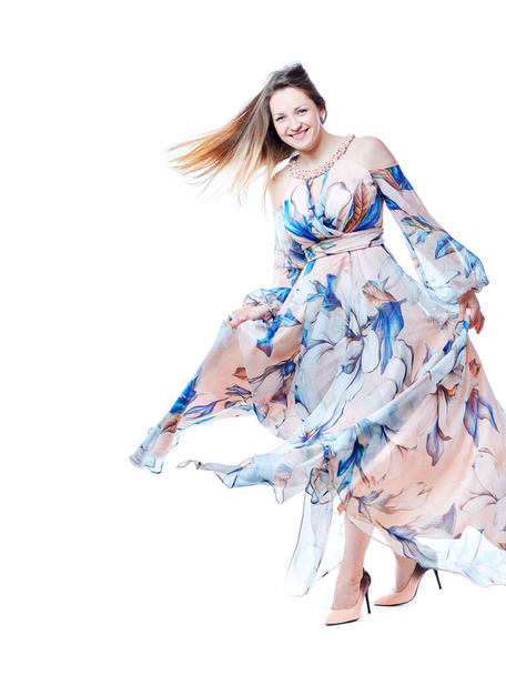 Girl in a long chic dress dancing on a white background - Foto, Imagem
