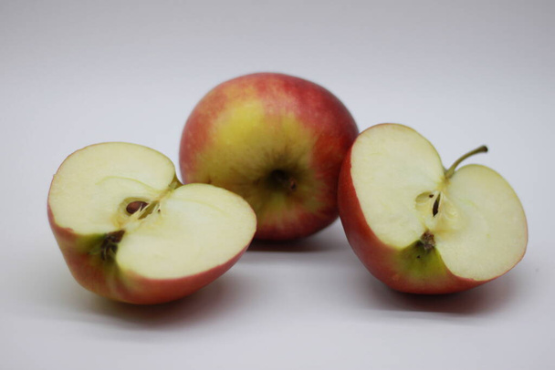 Pomme rouge coupée en deux sur fond blanc
 - Photo, image
