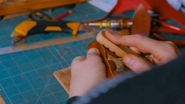 Skinner trabajando con cinturón de cuero - Foto, imagen